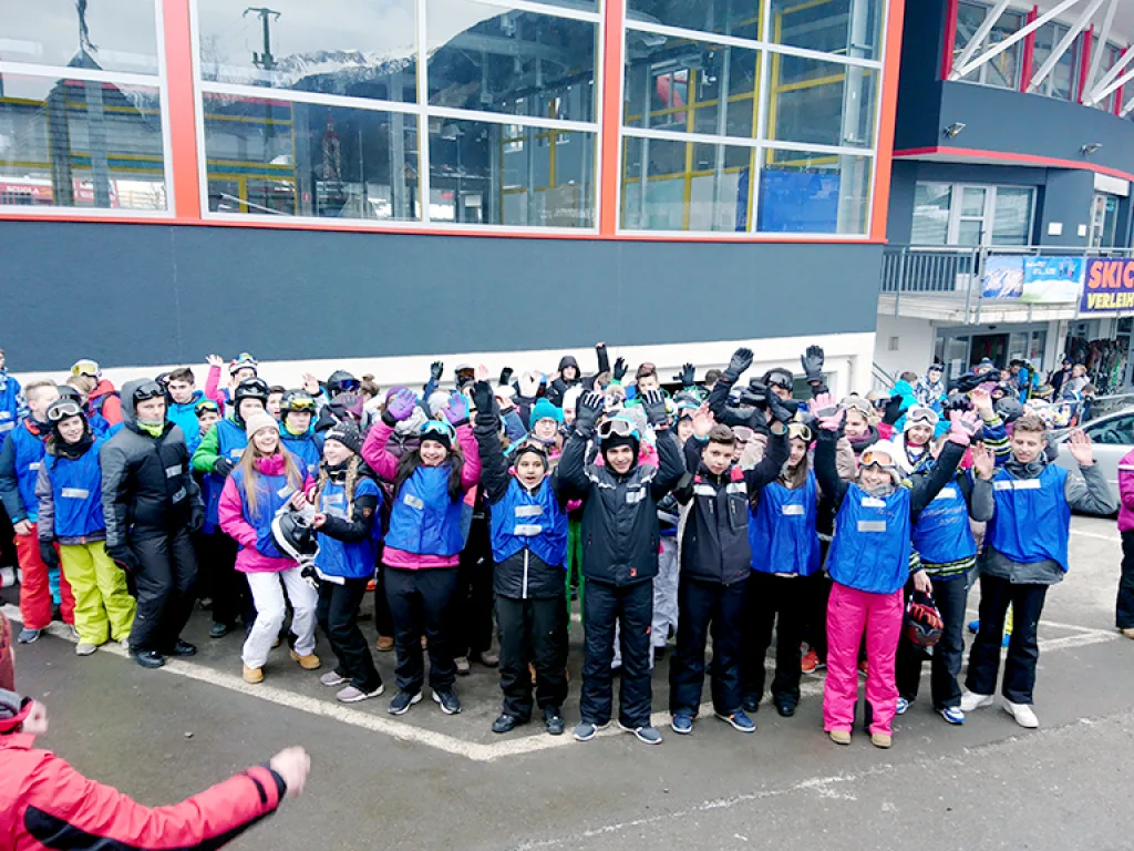 Große Gruppe versammelt sich vor dem Gebäude der Talstation.